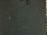 an old book with writing on it sitting on top of a table