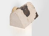 the wall light is made out of concrete and has a cow print on it