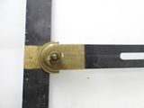 a close up of a metal ruler with a brass handle