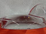 un canard en verre posé sur une nappe orange