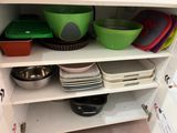 many bowls and pans on the shelves in the kitchen