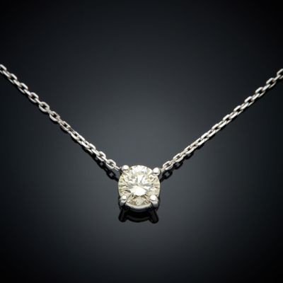 un pendentif en diamant suspendu à une chaîne sur fond noir