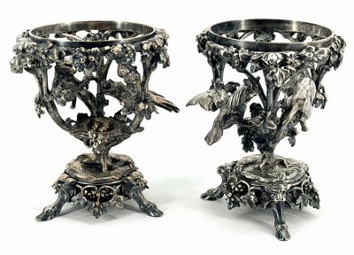 two silver vases with birds and flowers on them