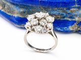 une photo en gros plan d'une bague en diamant posée sur un rocher