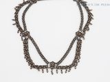 une photo en gros plan d'un collier posé sur une surface blanche