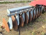a close up of a tractor with a disk attached to it ' s back