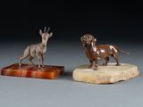 pair of bronze figurines of a dog and a goat on a marble base