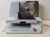 a silver and black food slicer sitting on top of a table