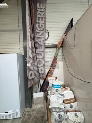 des sacs de nourriture posés par terre à côté d'un réfrigérateur