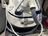 a white and blue steam iron sitting on top of a table