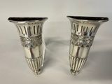 pair of silver vases sitting on a white surface with a white background