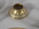a silver plate with a gold candle holder on it