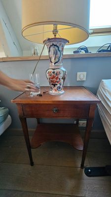 une femme debout à côté d'une table sur laquelle se trouve une lampe