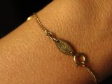 a close up of a person ' s arm with a gold bracelet