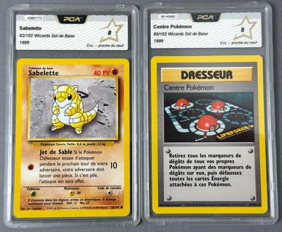 two pokemon cards with different designs on them sitting on a table