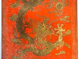 une image représentant un livre rouge et doré orné d'un dragon