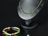 ensemble composé d'un collier et d'un bracelet en perles vertes, présenté sur un présentoir pour mannequin