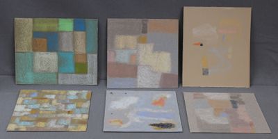 Quatre tableaux de couleurs et de formes différentes sont exposés sur une table