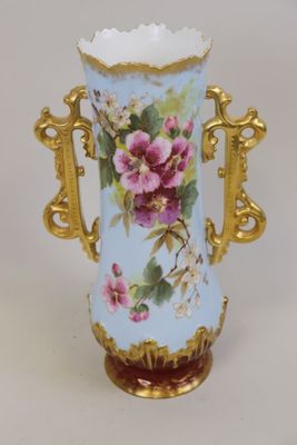 un vase bleu orné de fleurs roses, posé sur un fond blanc