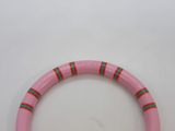 a pink bracelet with green and red stripes on it