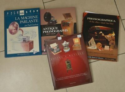 trois livres posés sur un sol carrelé de carreaux blancs