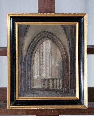 une vieille photo d'une église, encadrée, posée sur une étagère