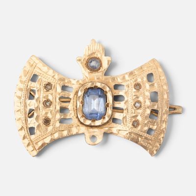 une image représentant une broche en or ornée d'une pierre bleue au centre