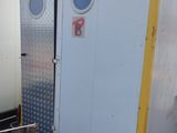 two white and yellow portable toilets sitting in a lot
