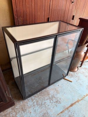 une vitrine en verre dans le coin d'une pièce