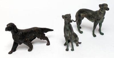 three figurines of dogs standing next to each other on a white surface