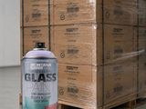 un pot de peinture posé sur une palette à côté d'une pile de cartons
