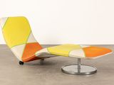 an orange, yellow and white chaise lounger with a metal base