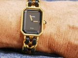 a woman wearing a gold and black watch on her wrist
