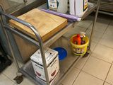 a metal cart with a cutting board on it in a kitchen
