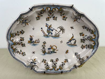 une assiette décorée d'un oiseau et de fleurs, posée sur une table