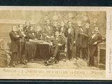 une vieille photo montrant un groupe d'hommes assis autour d'une table