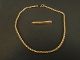 a gold chain with a clasp on a black surface