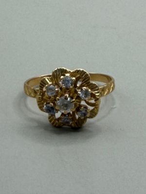 une bague en or sertie de diamants, posée sur un fond blanc