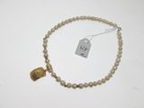 gros plan d'un collier sur une surface blanche avec une étiquette