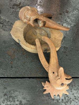 un objet en bois posé par terre à côté d'une paire de ciseaux