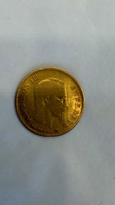 gros plan d'une pièce d'or sur une surface blanche