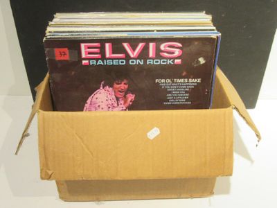 une boîte remplie de disques d'Elvis posée sur une table