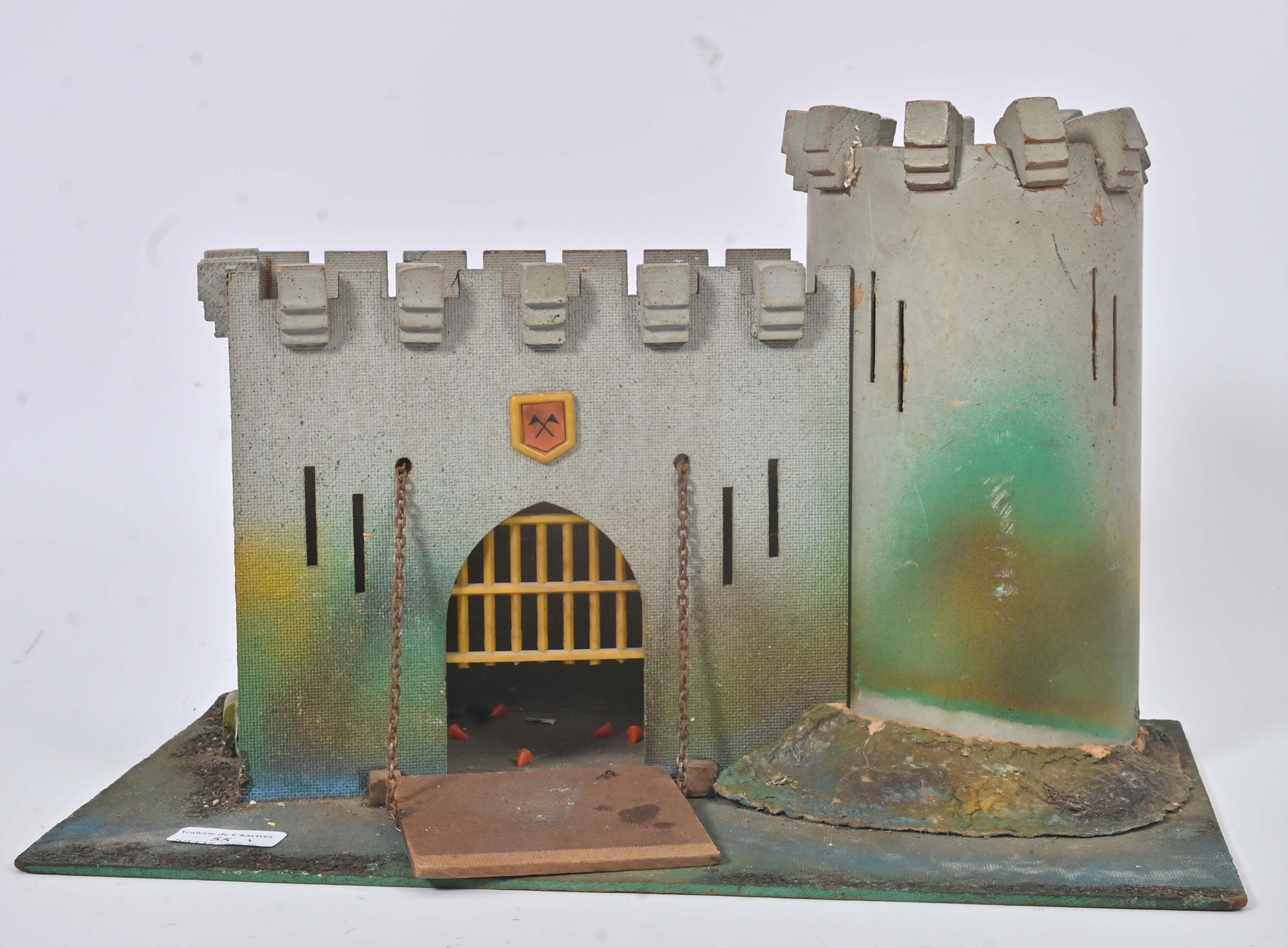 Château-fort avec pont-levis et tour de garde en carton peint, (usures d'usage). 25 x 40 cm.