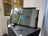 une télévision à écran plat posée sur un meuble noir