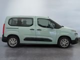 the green van is parked in the empty room on the concrete floor