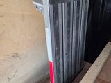 a radiator that is sitting on the floor next to a piece of wood
