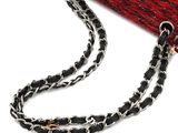 red and black knitted purse with chain strap on white background