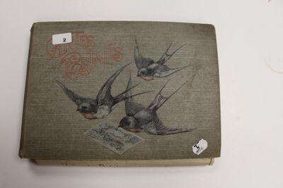 un vieux livre sur lequel sont représentés trois oiseaux, posé sur une table