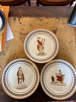 three plates with different designs on them sitting on a table