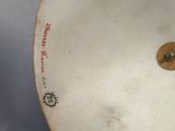 a white plate with a brown button on it